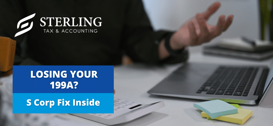 image of a business owner sitting at a desk. We can see his hands and he is holding one hand palm facing up. His laptop is open and there are office supplies and a calculator on his desk. He is looking at Section 199A deduction.